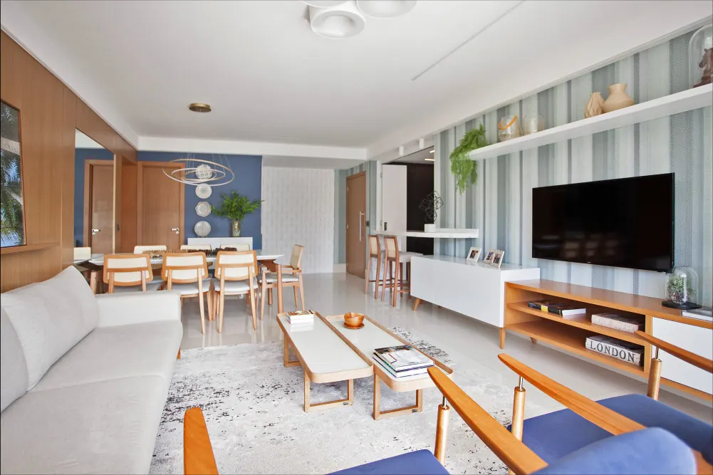 Living e jantar integrados com painel de madeira e parede azul no apartamento Hoje mais que Ontem